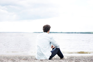 A person contemplating on the beach