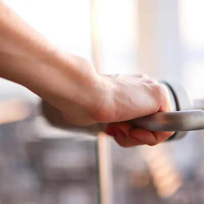 A hand turning a door handle, as if to open their professor's door