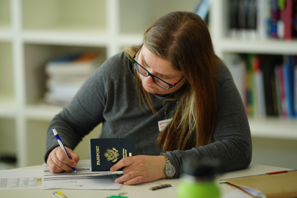 A staff member helping students with the Passport registration