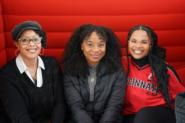 Two girls taking a picture with Ebonie Rayford, staff member of OSL